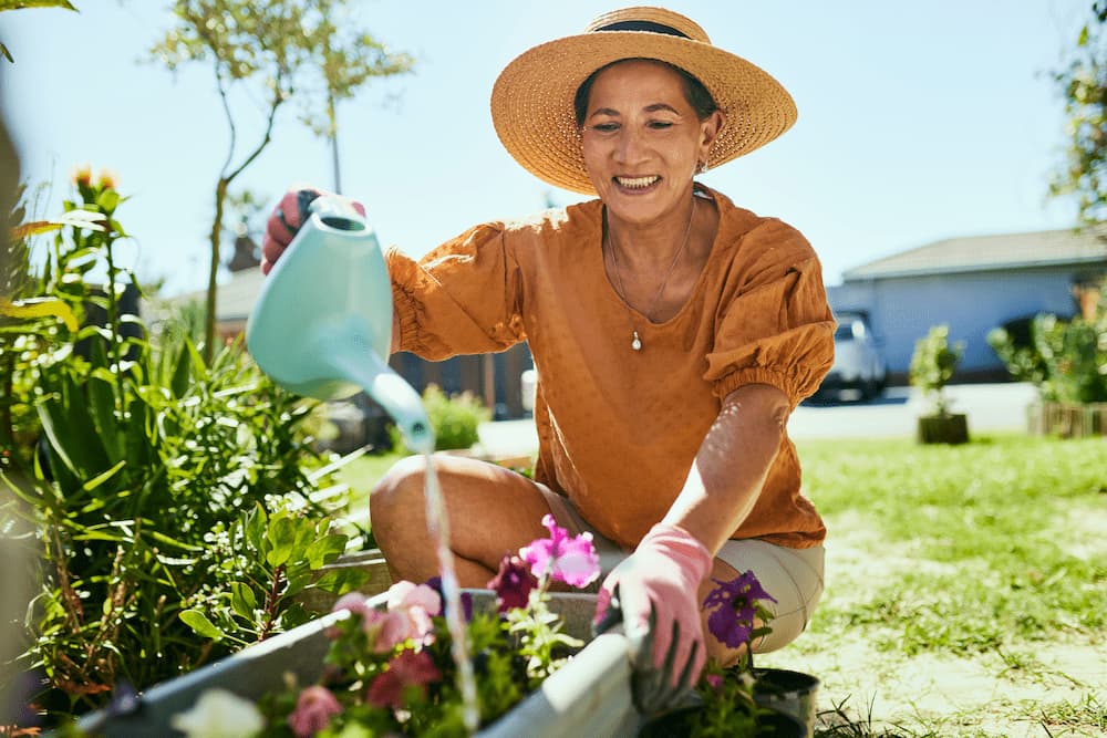 Women smiling while pouring water on flowers.