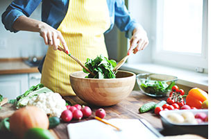 Person preparing a healthy salad.