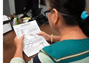 Looking over the shoulder of a woman reading words to speech pathologists.