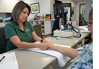 Physical therapist helping patient recover from a wrist fracture.