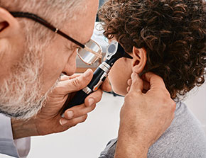 Doctor examining child's ear.