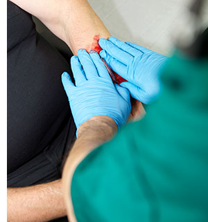 Doctor treating laceration wound.