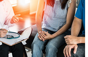 Doctor counseling young couple with STDs