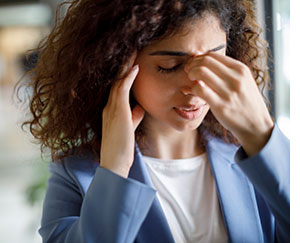 Woman showing signs of a headache.
